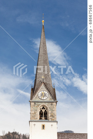 A close up of the bell tower of the Catholic parish church of Bruck an der Grossglocknerstrasse in the state of Salzburg, Austria. 68667566