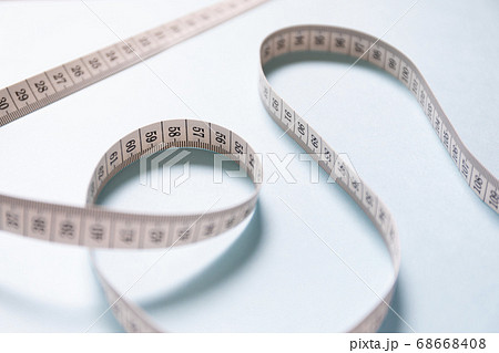 ランダムに置かれた巻尺　薄い水色の背景 68668408