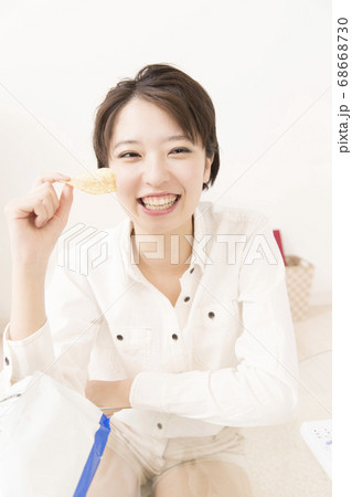 ポテトチップスを食べる女性 68668730
