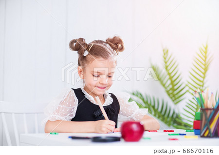 Happy smiling pupil at the desk. Girl in the class room with pencils, books. Kid girl from primary school. first day of fall. Back to school 68670116