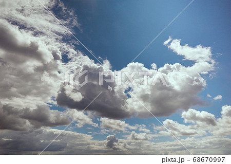 Cumulus clouds illuminated by bright sunlight in blue sky 68670997