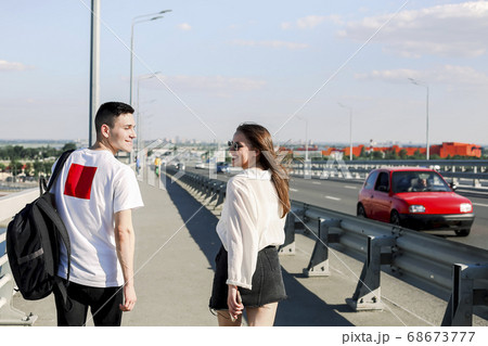 Happy couple walking along bridge 68673777