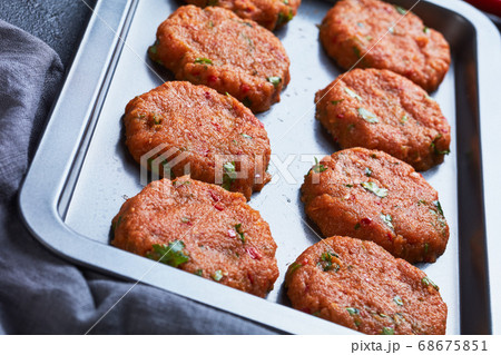 raw thai fish cakes on a baking sheet 68675851