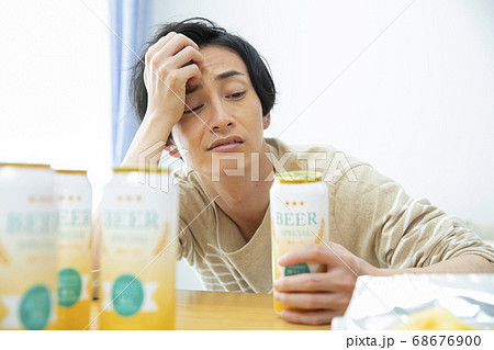 一人で部屋でビールを飲む男性 68676900