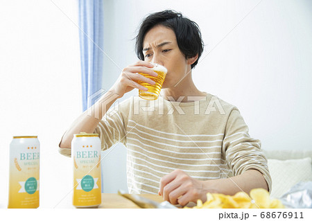 一人で部屋でビールを飲む男性 68676911