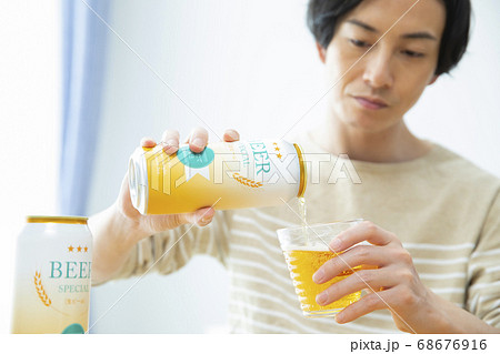 一人で部屋でビールを飲む男性 68676916
