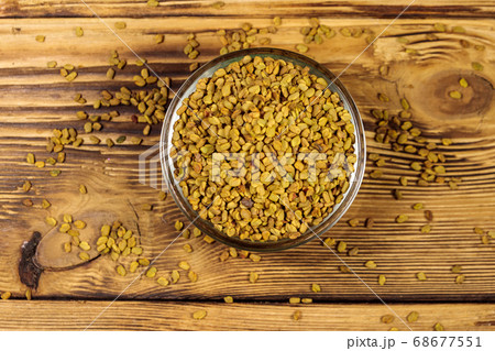 Fenugreek seeds in glass bowl on wooden table 68677551