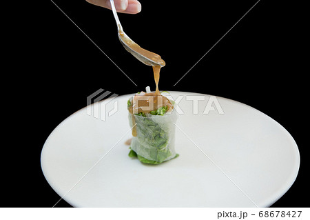 Spoon with sweet sauce put on fresh spring rolls 68678427