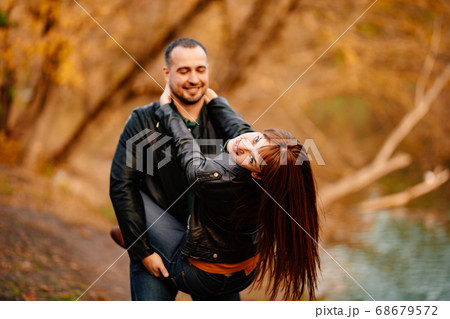 man and woman flirt in autumn park near river. 68679572