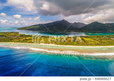 Aerial French Polynesia luxury travel honeymoon destination. Beach vacation at motu island of Huahine, Tahiti, Oceania adventure. View from above of paradise, French Polynesia, South Pacific Ocean. 68680627