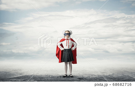 Girl power concept with cute kid guardian against cloudscape background . Mixed media Girl power concept with cute kid guardian against cloudscape background . Mixed media 68682716