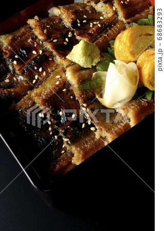 ワサビやガリや卵焼きが乗った沢山の穴子を使った小骨に注意の穴子重(黒背景、俯瞰) ワサビやガリや卵焼きが乗った沢山の穴子を使った小骨に注意の穴子重(黒背景、俯瞰) 68683293