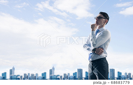 Concept of business success and control with confident boss against cityscape background Concept of business success and control with confident boss against cityscape background 68683779