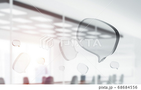 Concept of communication by glass empty chat icon on office background. Mixed media Concept of communication by glass empty chat icon on office background. Mixed media 68684556