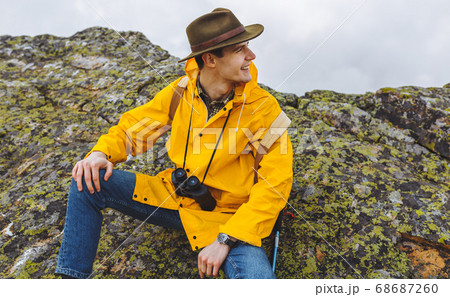 cheerful happy handsome hiker sitting on the big stones 68687260