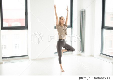 sporty young woman with streatched arms doing morning exercise 68688534