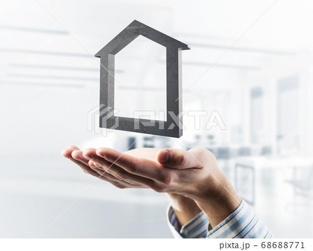 Concept of success and apartments presented by stone symbol in male palms. Mixed media 68688771