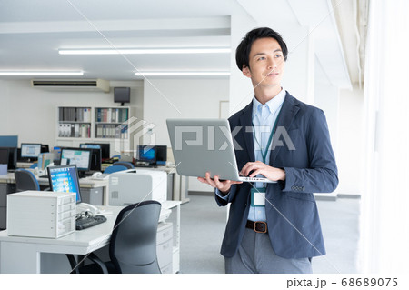 早朝1人でオフィスに出社してメールチェックをする若いビジネスマン 早朝1人でオフィスに出社してメールチェックをする若いビジネスマン 68689075