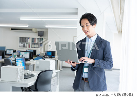 早朝1人でオフィスに出社してメールチェックをする若いビジネスマン 早朝1人でオフィスに出社してメールチェックをする若いビジネスマン 68689083