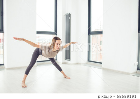 Young fashionable sportswoman wearing trendy sport outfit bending forward 68689191
