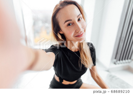 positive attractive sportswoman takinga selfie during the yoga training 68689210