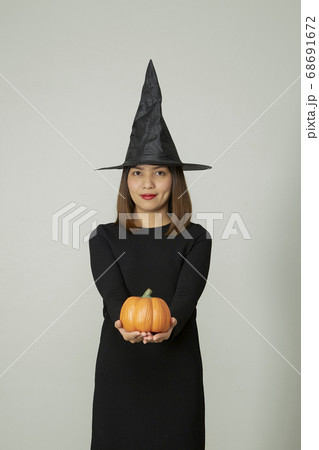 Halloween witch holding orange pumpkin Halloween witch holding orange pumpkin 68691672