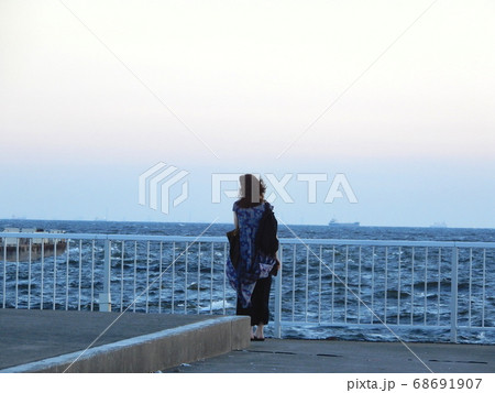 東京湾の夕暮れの海を見ている一人の女性の後ろ姿 68691907