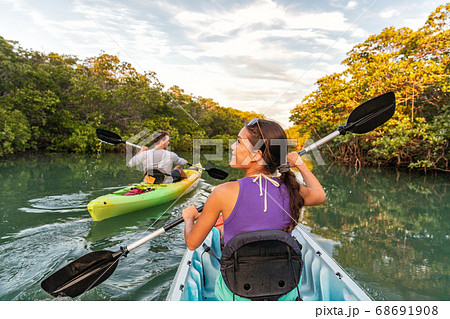 Couple kayaking together in mangrove river of the Keys, Florida, USA. Tourists kayakers touring the river of Islamorada 68691908