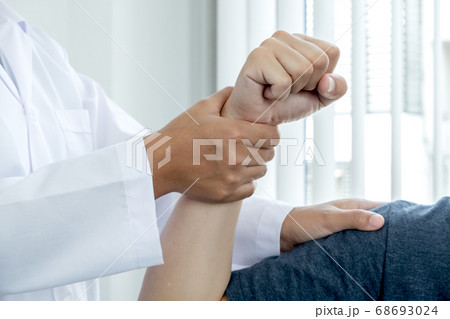 Female physiotherapists provide assistance to male patients with elbow injuries examine patients in rehabilitation centers 68693024