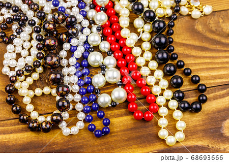 Different beads necklaces on wooden background Different beads necklaces on wooden background 68693666