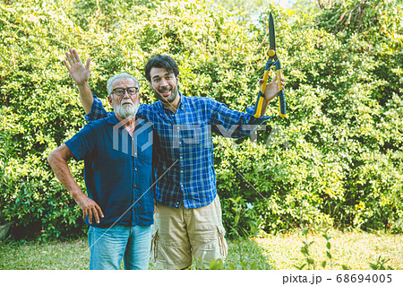 Happy gardener, elder with man enjoy pruning bushes at backyard for stay home activity in holiday 68694005