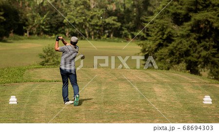 Professional golfer makes a kick on the ball 68694303