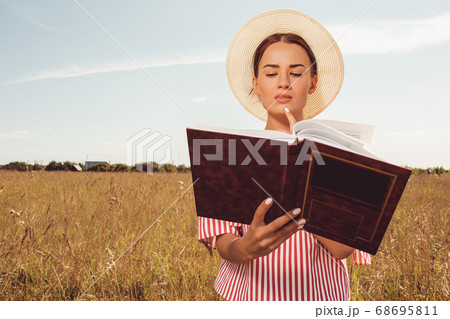 Portrait beautiful girl reading a book in the field Portrait beautiful girl reading a book in the field 68695811