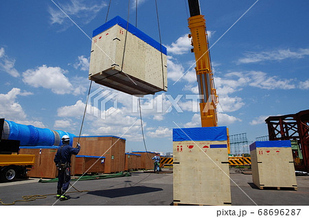 木箱で輸出梱包された荷物をクレーンで吊り上げる 68696287