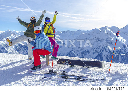 Three happy friends snowboarders and skiers are Three happy friends snowboarders and skiers are 68698542