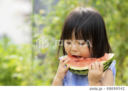 畑で採れた新鮮なスイカを食べる子供 68699542