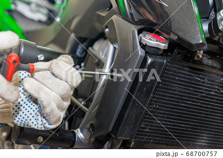 The master performs maintenance on the motorcycle. The master performs maintenance on the motorcycle. 68700757