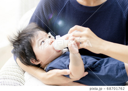 生後5ヶ月の赤ちゃんにミルクをあげる母親 生後5ヶ月の赤ちゃんにミルクをあげる母親 68701762