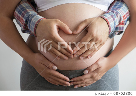 Close up shot of young man hugging his pregnant 68702806