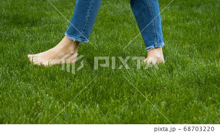 Woman stepping on mown lawn on backyard  68703220