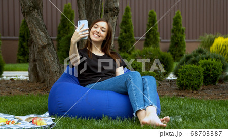 Young woman having video call in garden 68703387
