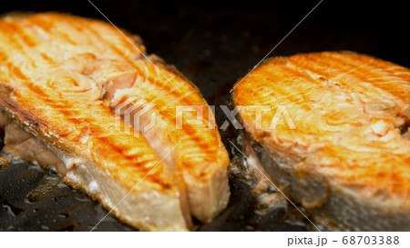 Fish salmon cuts being grilled in garden  68703388