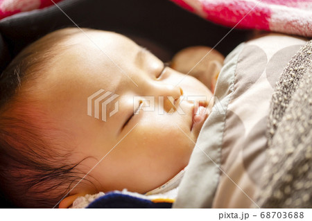 昼間に赤ちゃんが寝ている寝顔のアップの写真素材