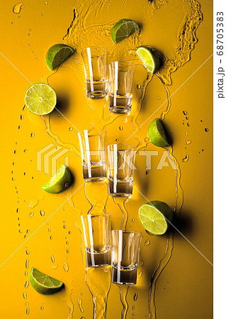 Shot glasses with lime slices and flowing Shot glasses with lime slices and flowing 68705383