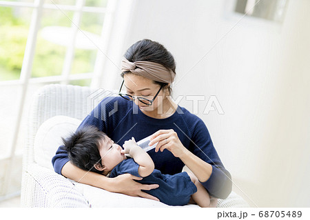 生後5ヶ月の赤ちゃんにミルクをあげる母親の写真素材