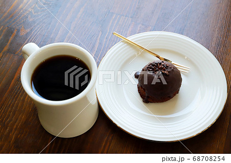 木製テーブルにあるホットコーヒーとチョコケーキ 68708254