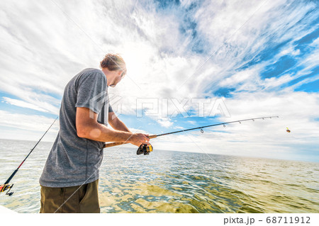 Fishing in Everglades, Florida USA summer vacation travel. Tourist man fishing in the sea from boat casting bait throwing line 68711912