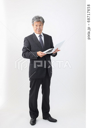 ノートパソコン持った全身スーツ姿  企業主 社長 重役 売上などパソコンチェック 68717658