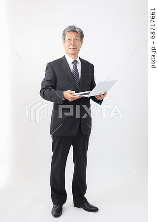 ノートパソコン持った全身スーツ姿 企業主 社長 重役 売上などパソコンチェック ノートパソコン持った全身スーツ姿 企業主 社長 重役 売上などパソコンチェック 68717661