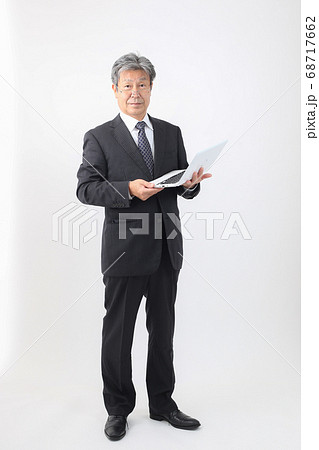 ノートパソコン持った全身スーツ姿  企業主 社長 重役 売上などパソコンチェック 68717662